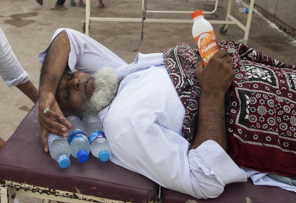 FILE - An elderly man suffering from heatstroke waits for a medical help at a local hospital in Karachi, Pakistan, Friday, June 26, 2015, during a heat wave that struck southern Pakistan. (AP Photo/Shakil Adil, File)