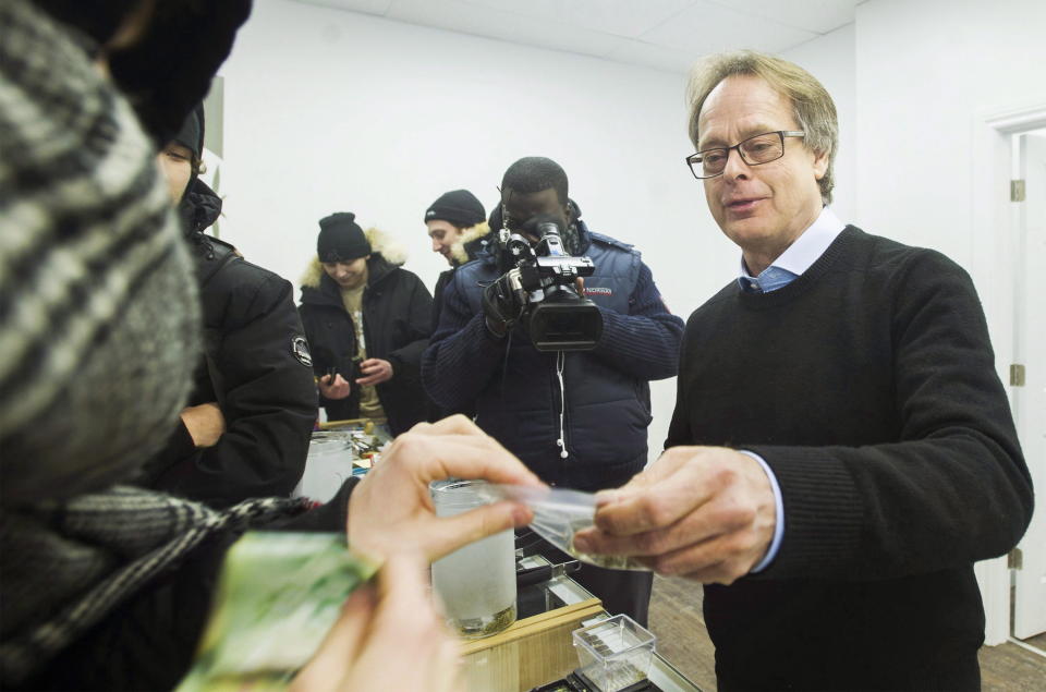 Marc Emery hands over a bag of marijuana to a customer at Cannabis Culture in Montreal on Dec. 16, 2016. (Photo: GRAHAM HUGHES/CANADIAN PRESS)