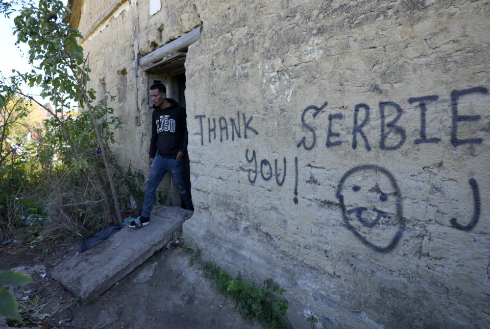 A migrant leaves an abandoned house at a makeshift camp near a border line between Serbia and Hungary, near village of Horgos, Serbia, Thursday, Oct. 20, 2022. Located at the heart of the so-called Balkan route, Serbia recently has seen a sharp rise in arrivals of migrants passing through the country in search of a better future in the West. (AP Photo/Darko Vojinovic)