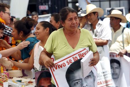 The mother of a missing student holds back tears after receiving a copy of the final report on the disappearance of the 43 students at Ayotzinapa teacher training college by members of the Inter-American Commission on Human Rights (IACHR) in Tixtla, Guerrero state, Mexico, April 27, 2016. REUTERS/Ginnette Riquelme