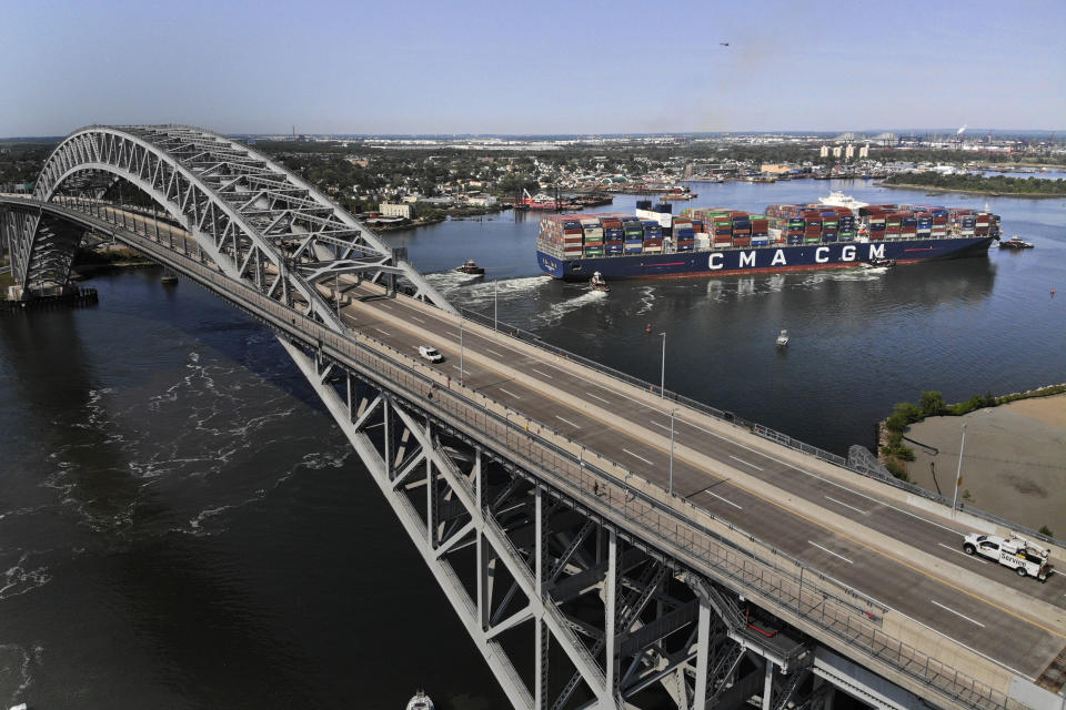 The CMA CGM Marco Polo, right, passes underneath the Bayonne Bridge on its way to the Elizabeth-Port Authority Marine Terminal as seen from Bayonne, N.J., Thursday, May 20, 2021. When the CMA CGM Marco Polo docks in New Jersey Thursday it will set a record for the largest container ship ever to visit the East Coast, a reflection both of the New York/New Jersey port system's multibillion-dollar efforts to accommodate larger ships and of the surging demand nationwide for products as COVID-19 restrictions continue to ease. (AP Photo/Seth Wenig)