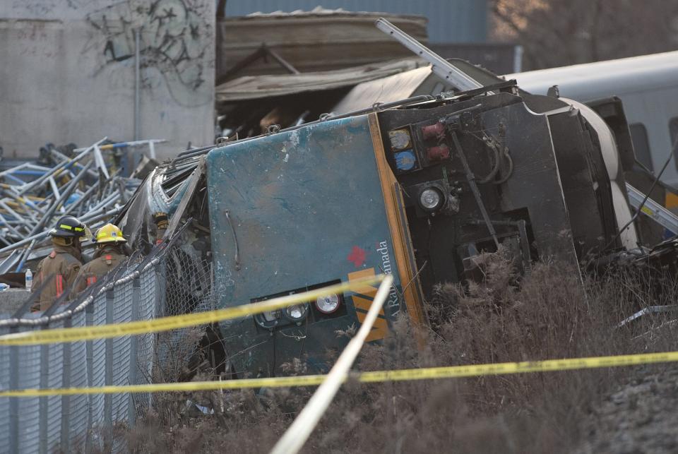 Rescue crews work on a derailed Via Rail passenger train in Burlington, Ontario on Sunday, Feb. 26, 2012. Burlington Mayor Rick Goldring says three people are dead after the Toronto-bound train derailed in his town. (AP Photo/The Canadian Press, Pawel Dwulit)