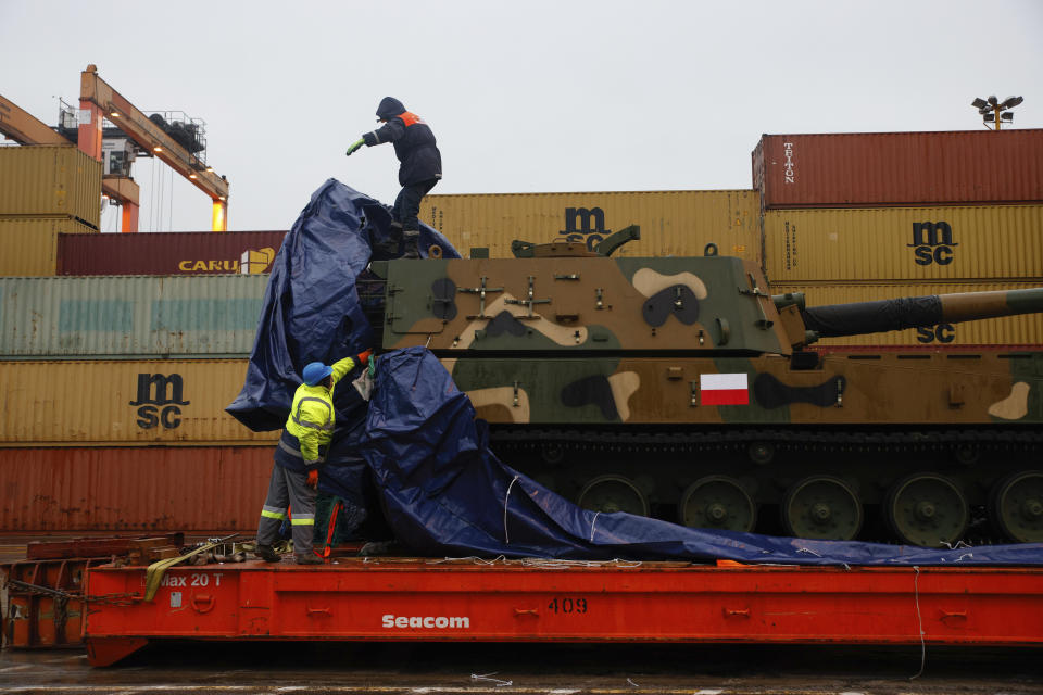 Workers uncover South Korean Thunder K9 howitzer in the Polish Navy port of Gdynia, Poland, Tuesday, Dec. 6, 2022. Poland's President Andrzej Duda and the defense minister on Tuesday welcomed the first delivery of tanks and howitzers from South Korea, hailing the swift implementation of a deal signed in the summer in the face of the war in neighbouring Ukraine. (AP Photo/Michal Dyjuk)