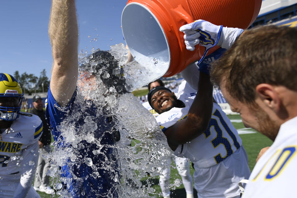 Delaware head coach Ryan Carty, left, gets doused by defensive back Brandon Dennis (31) and others after an NCAA college football game against Navy, Saturday, Sept. 3, 2022, in Annapolis, Md. Delaware won 14-7. (AP Photo/Nick Wass)