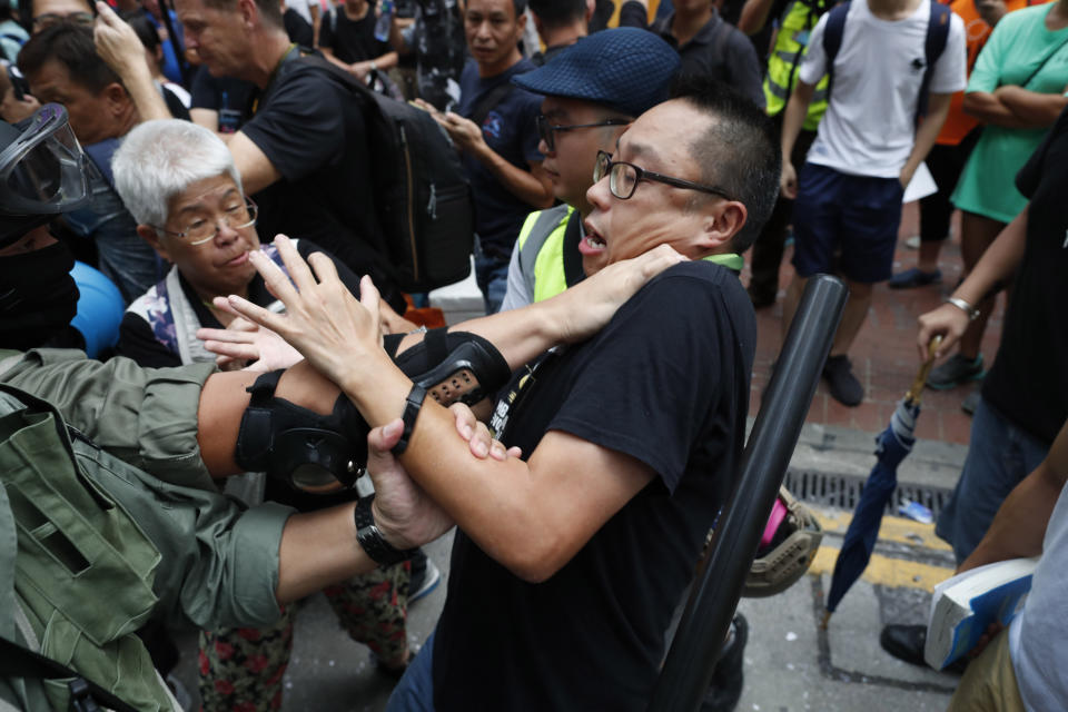 A protestor confronts police and gets detained in Hong Kong, Sunday, Sept. 29, 2019. Police on Saturday fired tear gas and water cannons after protesters threw bricks and firebombs at government buildings following a massive rally in downtown Hong Kong. The clashes were part of a familiar cycle since protests began in June over a now-shelved extradition bill and have since snowballed into an anti-China movement with demands for democratic reforms. (AP Photo/Gemunu Amarasinghe)