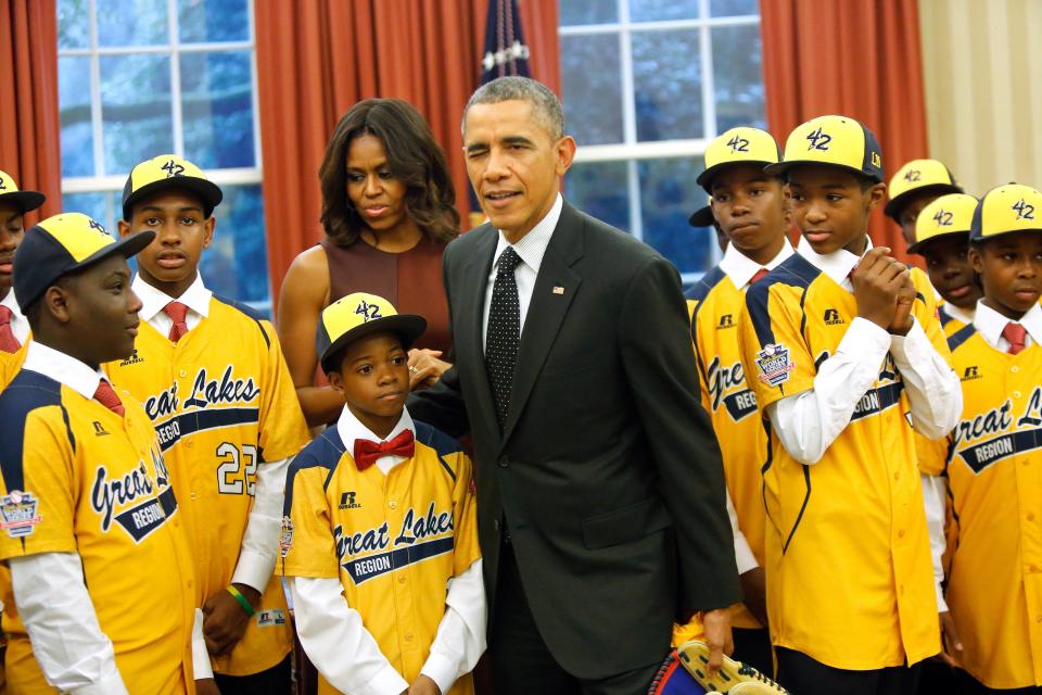 Obama winks at departing photographers after having his picture taken with members of the Jackie Robinson West All Stars Little League baseball team from Chicago in the Oval Office at the White House in Washington