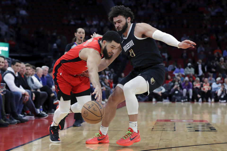 Houston Rockets guard Fred VanVleet, left, drives around Memphis Grizzlies forward David Roddy during the first half of an NBA basketball game Wednesday, Dec. 13, 2023, in Houston. (AP Photo/Michael Wyke)