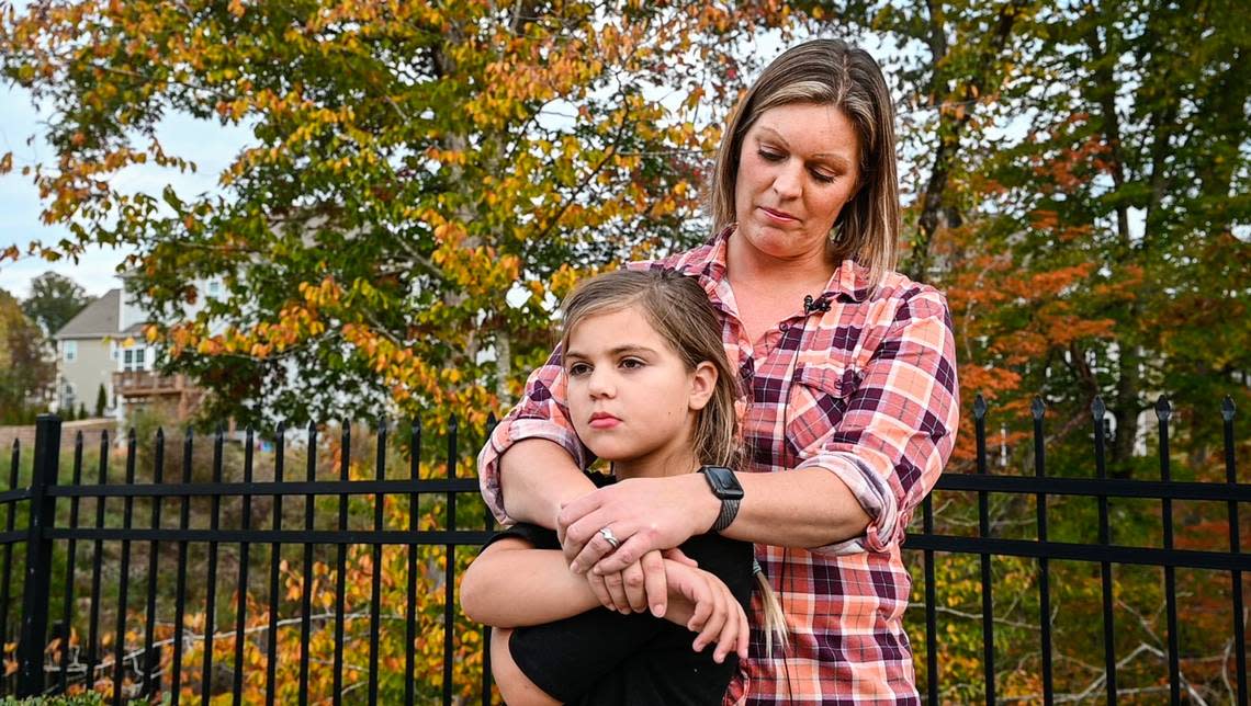 Sara Lanthorn and her daughter Addie, 8, stand outside their home on Nov. 2, 2021 in Waxhaw. Addie tested positive for COVID-19 on August 31st., during her first week back to school. Since then she has continued to experience a series of health issues related to COVID including shortness of breath when exerting energy, losing toenails, body aches and fatigue.