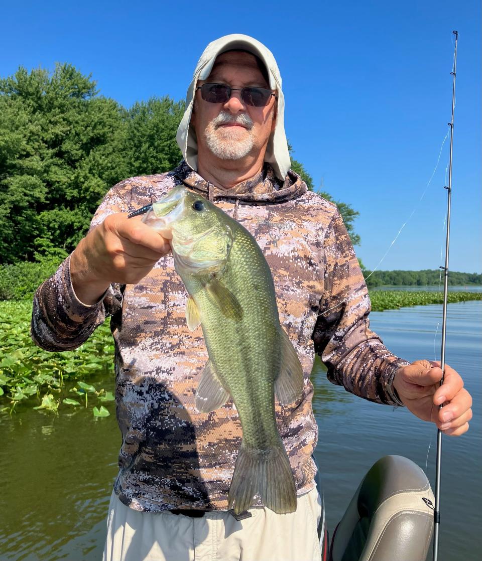 Outdoor correspondent Art Holden shows off the largemouth bass he caught out of the lily pads on a recent trip to Chippewa Lake in Medina County.