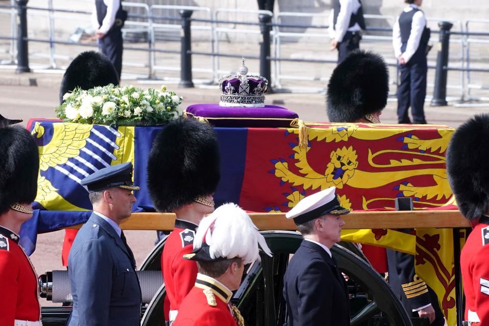 The coffin of Queen Elizabeth II, draped in the Royal Standard with the Imperial State Crown placed on top, is carried on a horse-drawn gun carriage of the King's Troop Royal Horse Artillery (AP)