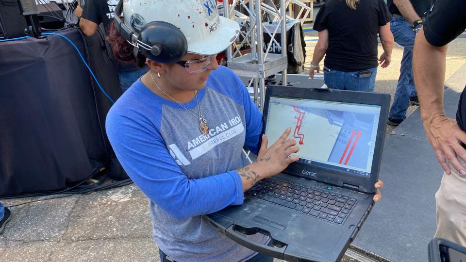 Fatima Medina, a pipefitter apprentice at Newport News Shipbuilding, shows off her laptop and digital work instructions during an Enterprise (CVN-80) keel laying media day on Aug. 26, 2022. (Megan Eckstein/Staff)