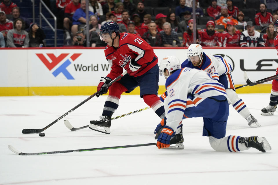 Washington Capitals right wing Garnet Hathaway, left, skates past Edmonton Oilers defensemen Evan Bouchard (2) and Brett Kulak (27) in the first period of an NHL hockey game, Monday, Nov. 7, 2022, in Washington. (AP Photo/Patrick Semansky)