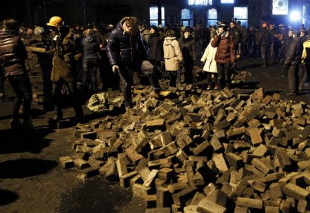 Anti-government protesters pass on bricks to help comrades to set up a barricade in central Kiev February 20, 2014. REUTERS/David Mdzinarishvili