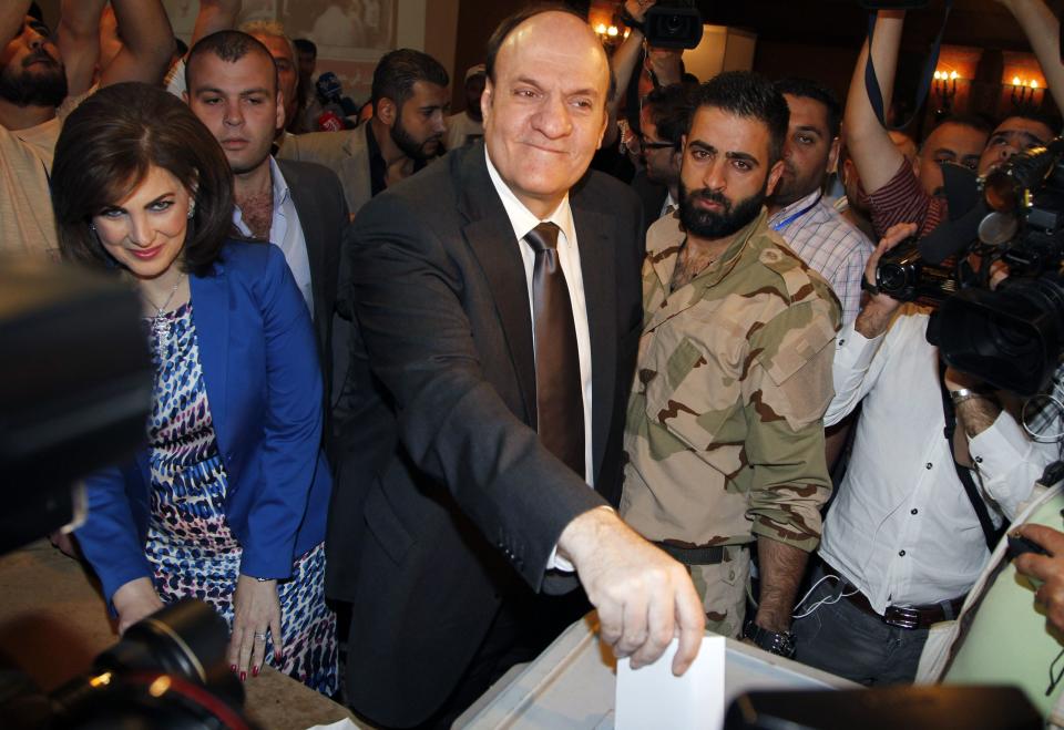 Syria's presidential candidate Hassan al-Nouri accompanied by his wife Hazar casts his vote at polling centre in Damascus June 3, 2014. Syrians voted on Tuesday in an election expected to deliver an overwhelming victory for President Bashar al-Assad but which his opponents have dismissed as a charade in the midst of Syria's devastating civil war. (REUTERS/Khaled al-Hariri)