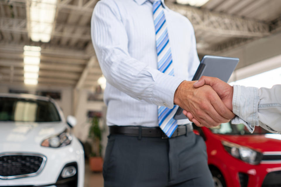 Car salesman shaking hands