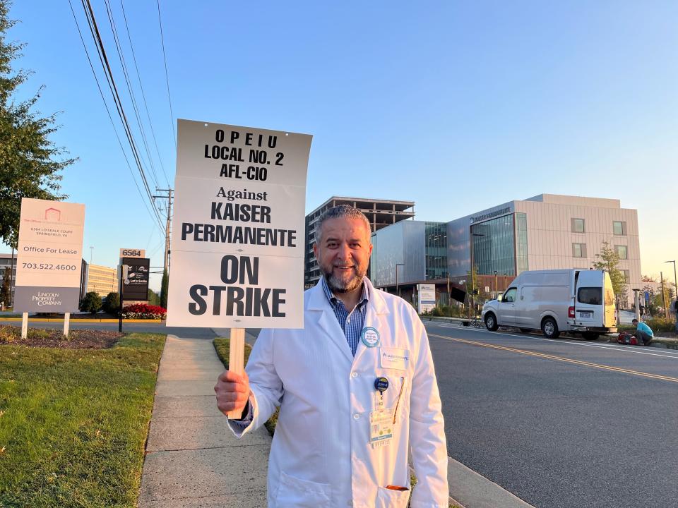 David Hawa, a pharmacist at Kaiser Permanente for 28 years, poses with his sign.