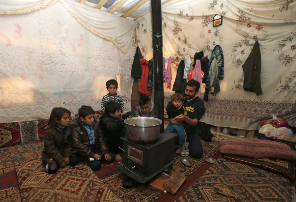 A Syrian refugee family sit inside their tent during a winter storm in Zahle town, in the Bekaa Valley December 11, 2013. The worst of winter is yet to come for 2.2 million refugees living outside Syria and millions more displaced inside the country. A storm named Alexa is sweeping across Syria and Lebanon, bringing with it high winds and freezing temperatures - and marking the beginning of the third winter since the Syrian conflict began in March 2011. In the tented settlement a few kilometres from the border in Lebanon's Bekaa Valley, more than 1,000 people live in rudimentary shelters. REUTERS/Mohamed Azakir (LEBANON - Tags: POLITICS CIVIL UNREST CONFLICT SOCIETY IMMIGRATION ENVIRONMENT)