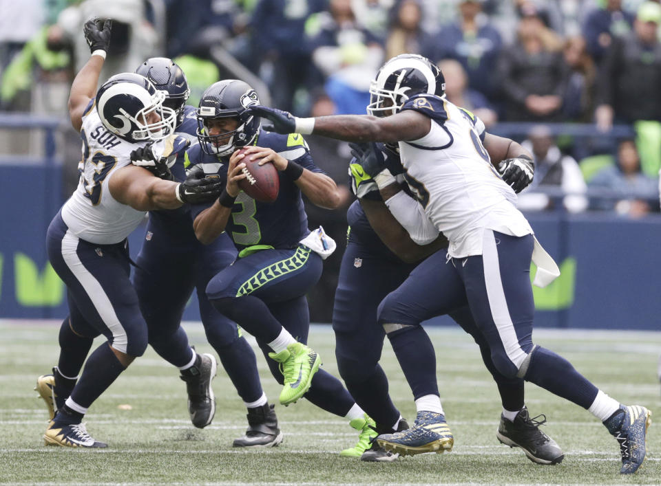 Los Angeles Rams defensive tackle Ndamukong Suh, left, moves in to sack Seattle Seahawks quarterback Russell Wilson (3) as Rams' Michael Brockers, right, looks on during the second half of an NFL football game, Sunday, Oct. 7, 2018, in Seattle. The Rams won 33-31. (AP Photo/Scott Eklund)