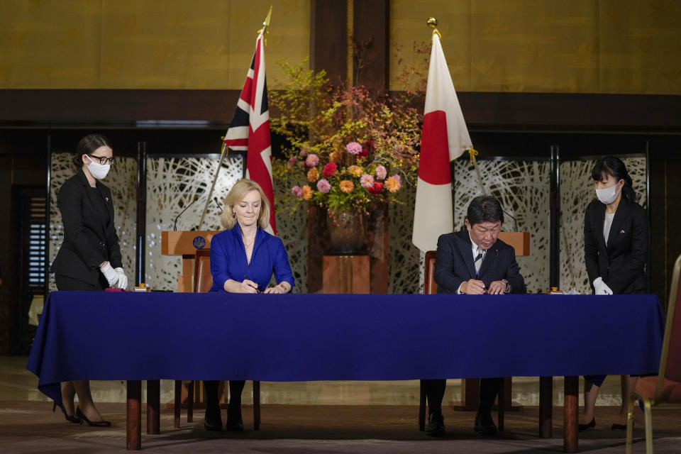 British International Trade Secretary Liz Truss, center left, signs a document with Japanese Foreign Minister Toshimitsu Motegi, center right, for economic partnership between Japan and Britain at Iikura Annex of the Foreign Ministry in Tokyo Friday, Oct. 23, 2020. Japan and Britain signed a bilateral free trade deal Friday in the the first such major post-Brexit deal, reducing tariffs on Yorkshire lamb sold in Japan, as well as auto parts for Japan’s Nissan plant. (Kimimasa Mayama/Pool Photo via AP)