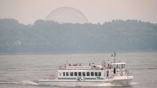 PHOTO: A tourist boat passes on the St. Lawrence river as the Biosphere is seen through the smoke filled skies caused by the wildfires in Northern Quebec in Montreal, Quebec, on June 25, 2023. (Andrej Ivanov/AFP via Getty Images)