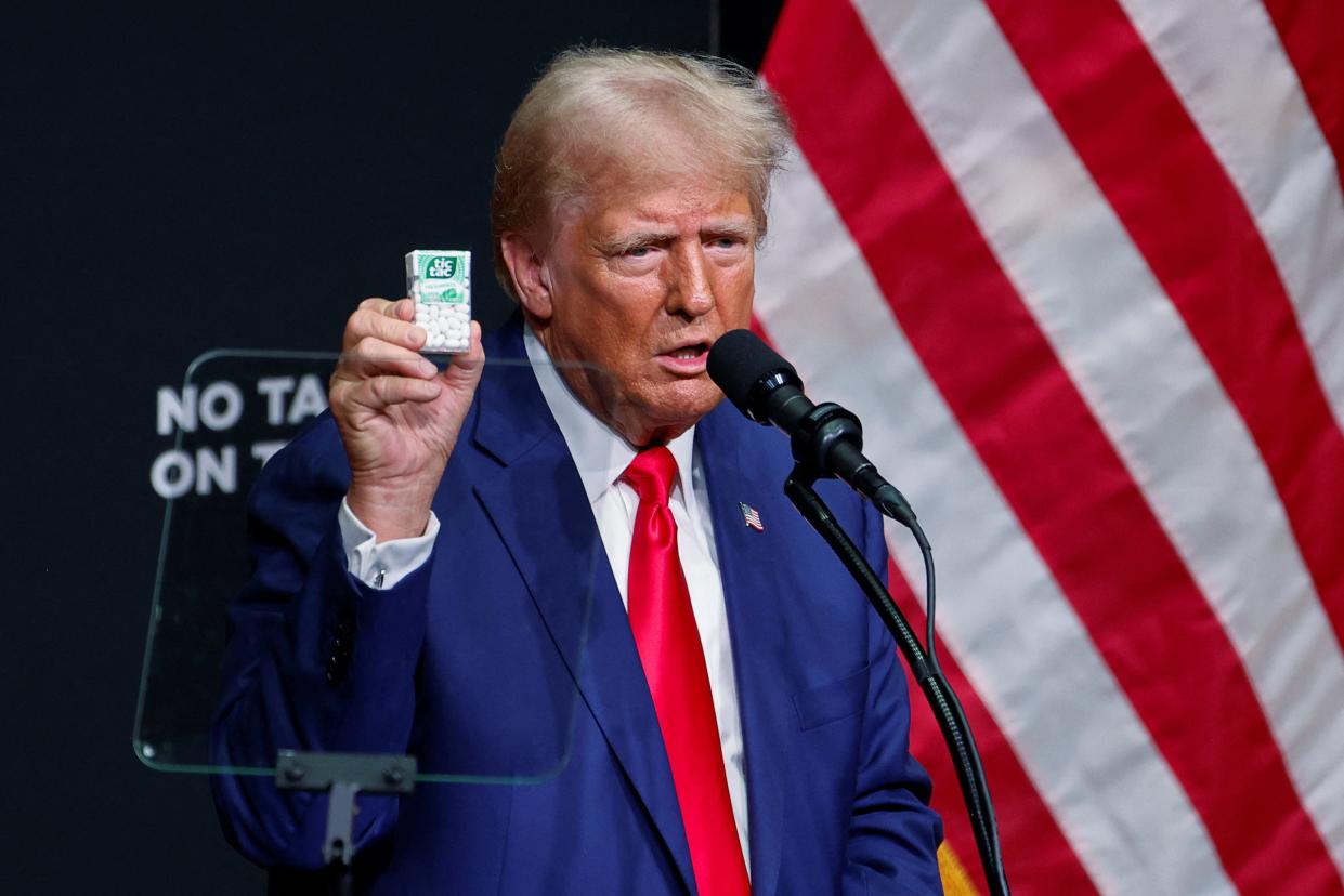 Republican presidential nominee and former U.S. President Donald Trump holds up a Tic Tac packet, as he speaks at a campaign event in Asheville, North Carolina, U.S. August 14, 2024. REUTERS/Jonathan Drake