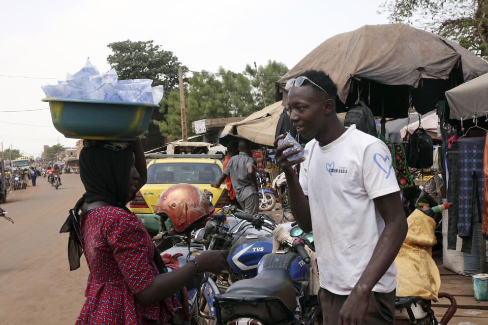 Amadou Coulibaly, a 25-years-old, motorcycle taxi driver, drinks a sachet water to cool off under a blazing sun.in Bamako, Mali, Thursday, April, 18, 2024. Street vendors in Mali's capital of Bamako peddle water sachets, ubiquitous for this part of West Africa during the hottest months of the year. On Thursday, temperatures in Bamako reached 44 degrees Celsius (111 Fahrenheit) and weather forecasts say it's not letting up anytime soon. (AP Photo/Baba Ahmed)