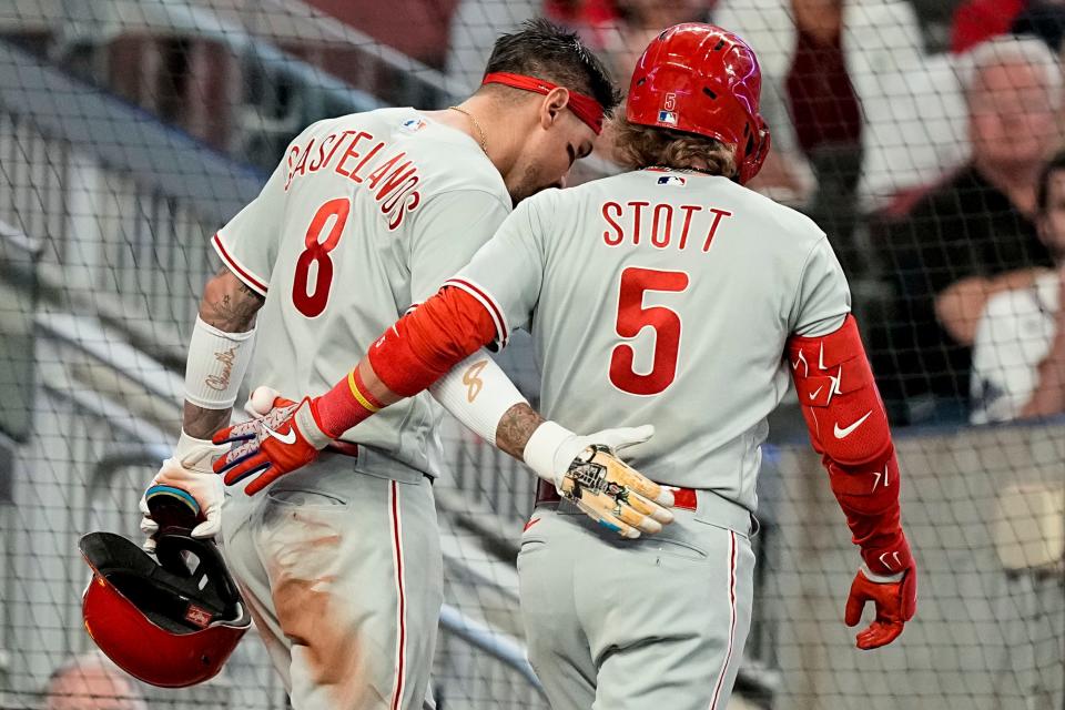 Philadelphia Phillies' Nick Castellanos (8) celebrates scoring a run with Bryson Stott (5) in the fifth inning of Game 2 of a baseball NL Division Series against the Atlanta Braves, Monday, Oct. 9, 2023, in Atlanta. (AP Photo/Brynn Anderson)