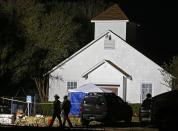 <p>Two Texas State Troopers walk past the church while investigators work at the scene of a mass shooting at the First Baptist Church in Sutherland Springs, Texas, Nov. 5, 2017. (Photo: Larry W. Smith/EPA-EFE/REX/Shutterstock) </p>