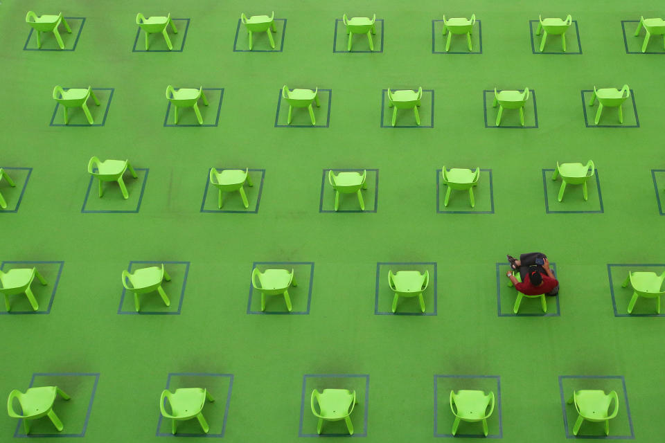 A man sits on a chair marked out to keep social distancing amid the COVID-19 pandemic on March 19, 2021 in Singapore. (Photo by Suhaimi Abdullah/NurPhoto via Getty Images)