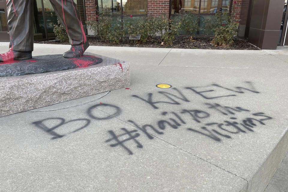 The statue of the late University of Michigan football coach Bo Schembechler was vandalized on Wednesday morning, Nov. 24, 2021 in Ann Arbor, Mich. The vandal referenced Schembechler's alleged knowledge of the late team doctor Robert Anderson's sex abuse of hundreds of players for multiple decades. (Sam Dodge/Jackson Citizen Patriot via AP)