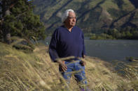 Bill Yallup Jr. stands at the banks of the Columbia River, where he and his son fish for salmon and trout, on Friday, June 17, 2022, in Bingen, Wash. Yallup's family came to Celilo Falls when he was an infant, and he lives along the river during the fish harvesting season. (AP Photo/Jessie Wardarski)