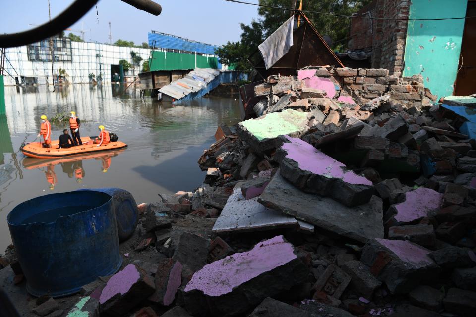National Disaster Response Force personnel inspect on a dinghy the area where some shanty houses collapsed into a canal due to heavy rains in New Delhi on July 19, 2020. (Photo by Sajjad HUSSAIN / AFP) (Photo by SAJJAD HUSSAIN/AFP via Getty Images)