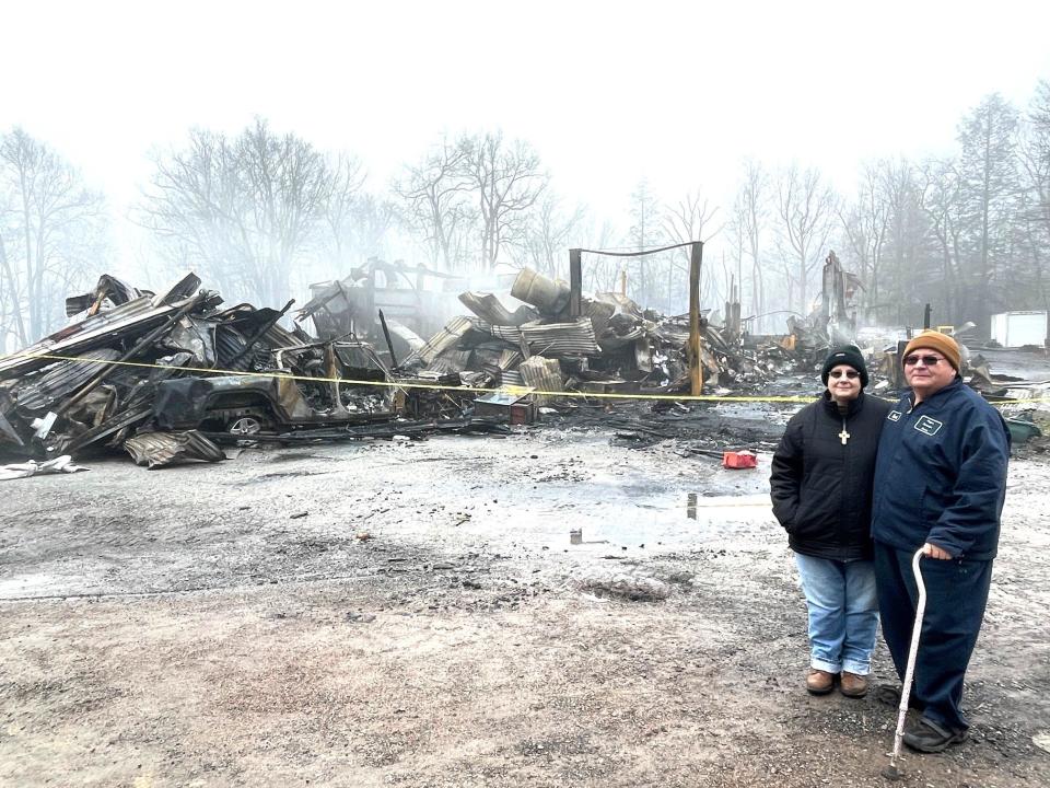 Laura and Robert Hauger look over what's left of Hauger Auto Sales and Body Shop in Stoystown after an early morning fire Saturday.