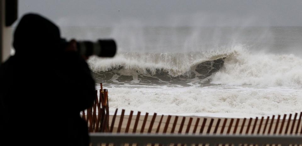 A man photographs the rough ocean surf on the Manasquan side of the inlet Monday, December 18, 2023. Overnight rainfall across Monmouth and Ocean totaled more than three inches in some areas, and storm conditions resulted in flooding and downed trees that have left around 17,000 residents without power.