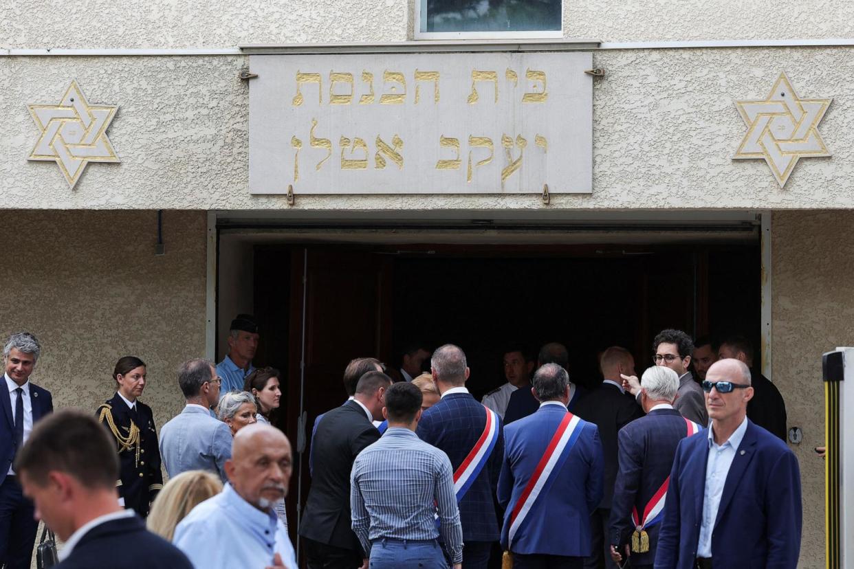 PHOTO: People stand by the entrance to the city's synagogue, after cars were set on fire in front of it, in La Grande-Motte, France, Aug. 24, 2024.  (Manon Cruz/Reuters)