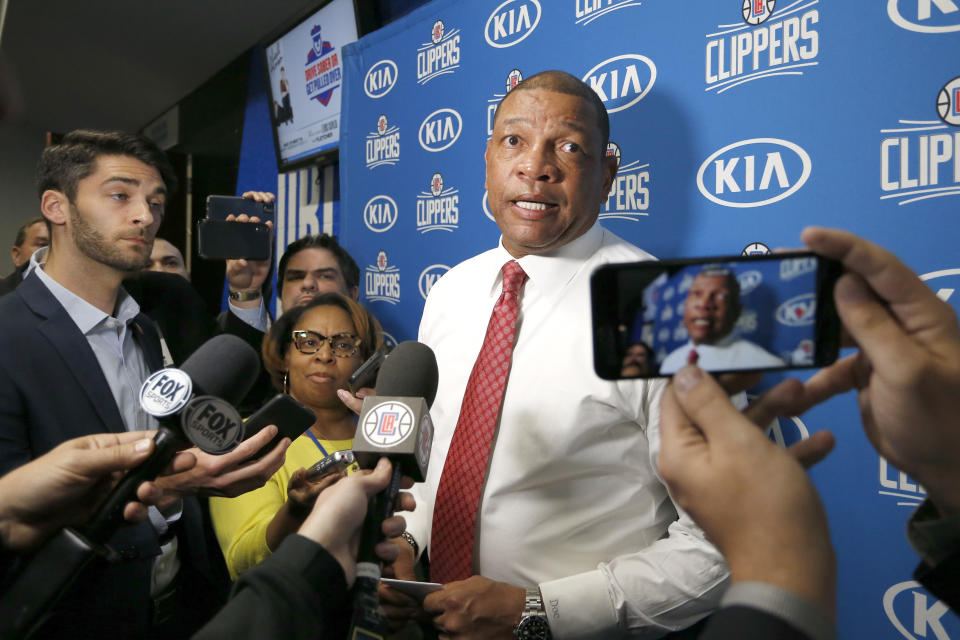 FILE- In this Jan. 26, 2020 file photo, Los Angeles Clippers head coach Doc Rivers talks with the media after an NBA basketball game against the Orlando Magic in Orlando, Fla. Rivers informed the media that there will be no interviews in the locker room that night as his players dealt with the loss of Kobe Bryant. River's remark to reporters, "We are all Lakers today," holds the number 10 position on the Yale Law School librarian's list of the most notable quotes of 2020. (AP Photo/Reinhold Matay, File))