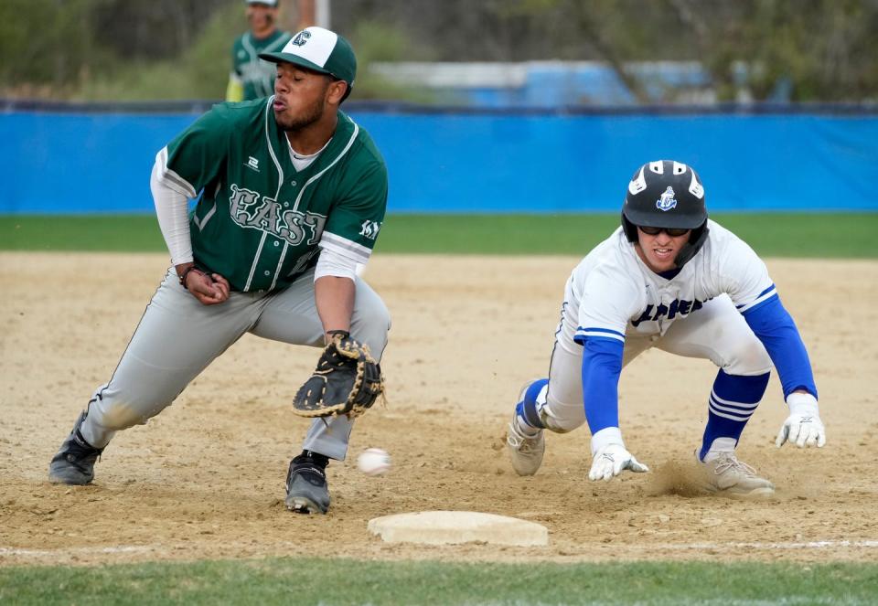 Bishop Hendricken first baseman Adrian Pimentel misses a low throw to first as Cumberland runner Anthony Martin dives safely back in a fourth-inning pickoff attempt.