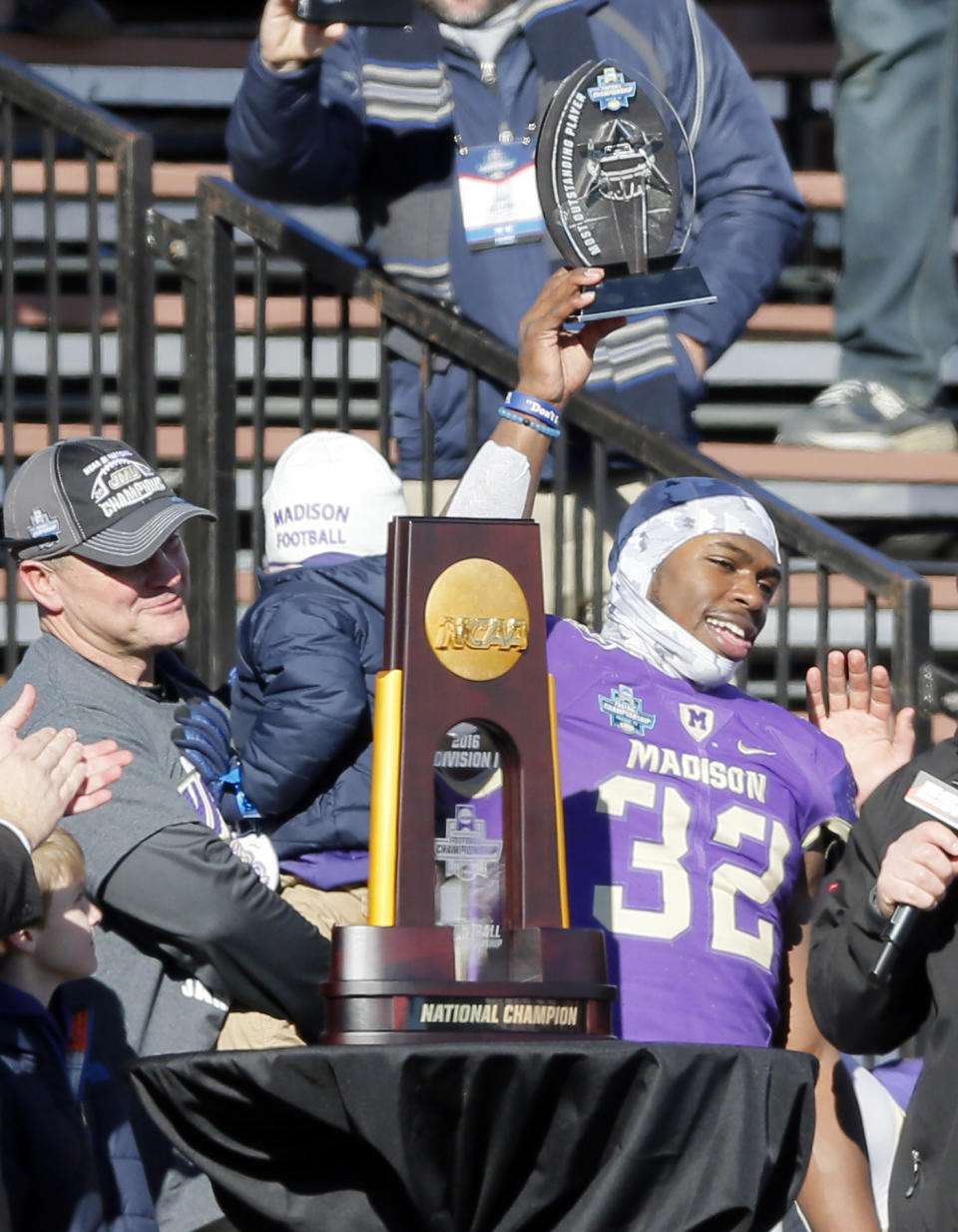 James Madison head coach Mike Houston, left, watches as running back Khalid Abdullah (32) holds up the most valuable player award after their 28-14 win over Youngstown State in the FCS championship NCAA college football game, Saturday, Jan. 7, 2017, in Frisco, Texas. (AP Photo/Tony Gutierrez)