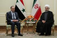 In a handout photo, Iranian President Hassan Rouhani (R) is seen meeting with Syrian Prime Minister Imad Khamis in Tehran January 18, 2017, the same day Iranian officials said they were opposed to the US joining Syrian peace talks in Kazakhstan