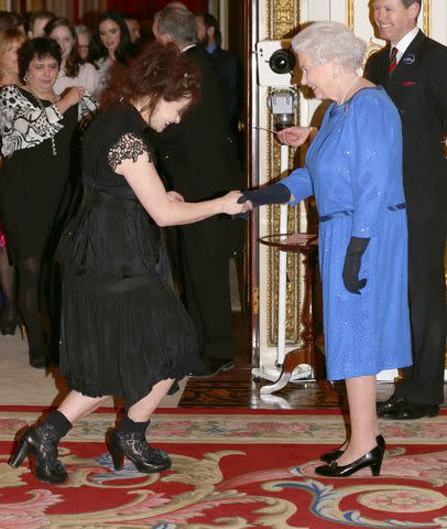 <p>Yui Mok - WPA Pool/Getty</p> Helena Bonham Carter curtsies to Queen Elizabeth at Buckingham Palace reception in Feb. 2014