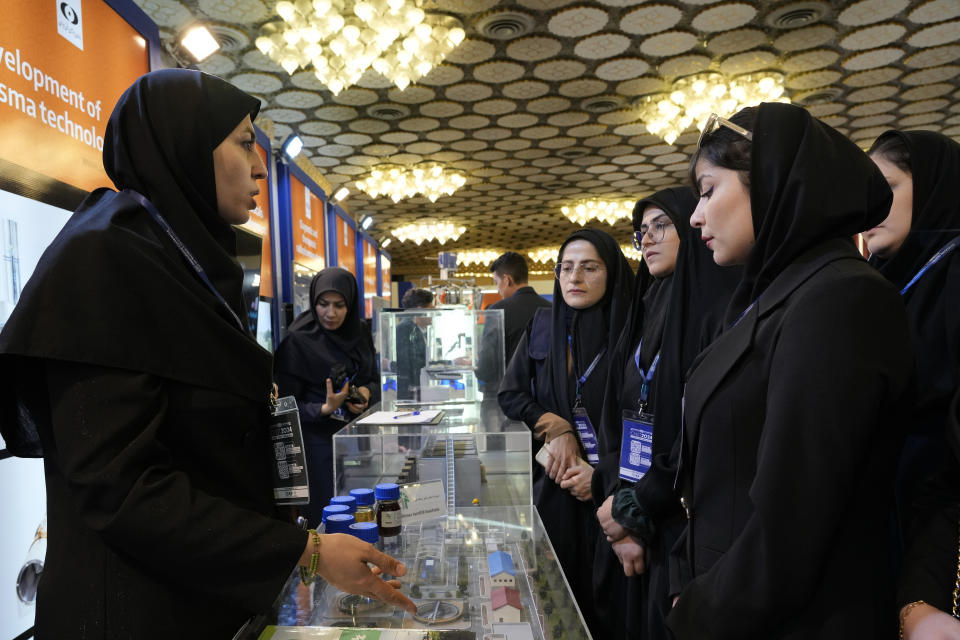 An Iran's Atomic Energy Organization expert speaks with participants of "International Conference on Nuclear Science and Technology" as they visit an exhibition of Iran's nuclear achievements in the central city of Isfahan, Iran, Monday, May 6, 2024. (AP Photo/Vahid Salemi)