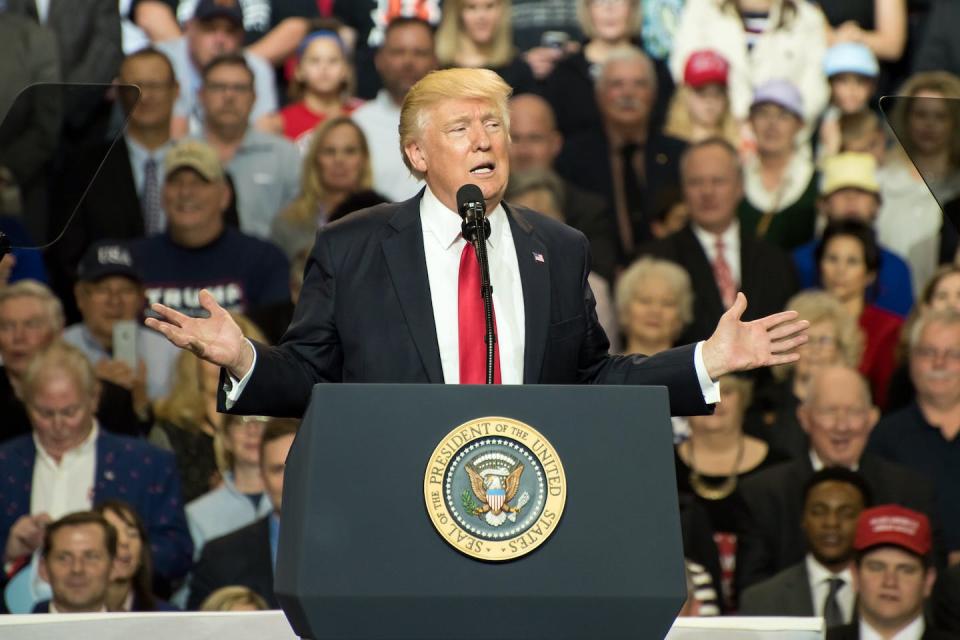 Donald Trump con los brazos extendidos dirigiéndose a una multitud en un mitin.