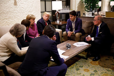 Canada's Prime Minister Justin Trudeau and G7 leaders France's President Emmanuel Macron, Germany's Chancellor Angela Merkel, Britain's Prime Minister Theresa May and U.S. President Donald Trump hold a meeting with staff on the first day of the G7 meeting in Charlevoix city of La Malbaie, Quebec, Canada, June 8, 2018. Picture taken June 8, 2018. Adam Scotti/Prime Minister's Office/Handout via REUTERS