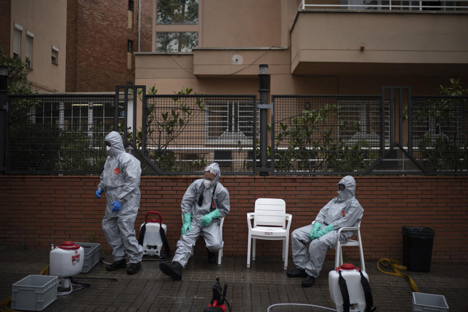 Ffirefighters wearing protective suits wait outside a nursing home before disinfecting it in efforts to prevent the spread of the new coronavirus in Barcelona, Spain, Monday, March 30, 2020. Governments in Europe's hardest-hit countries have yet to systematically test the residents of nursing homes or those who receive in-home care. In Spain, Italy and France, which together account for a third of the world's confirmed coronavirus cases, no one knows for sure how many people have become sick and died of coronavirus, especially among the elderly. The new coronavirus causes mild or moderate symptoms for most people, but for some, especially older adults and people with existing health problems, it can cause more severe illness or death. (AP Photo/Felipe Dana)