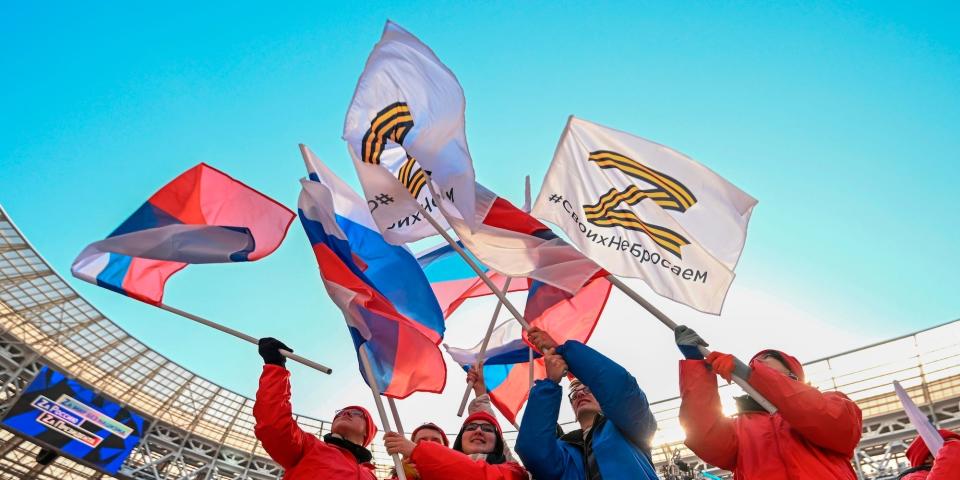 People wave Russian national flags and flags with the letter Z at a rally in Moscow, Russia, Friday, March 18, 2022.