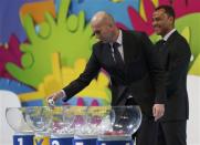 Former French soccer player Zinedine Zidane draws a ball from a pot as former Brazilian soccer player Cafu looks on, during the draw for the 2014 World Cup at the Costa do Sauipe resort in Sao Joao da Mata, Bahia state, December 6, 2013. REUTERS/Ricardo Moraes
