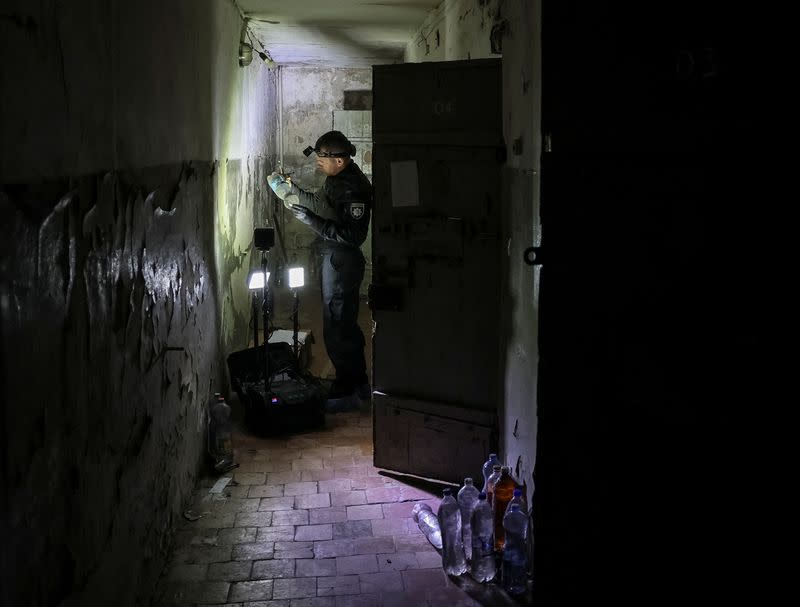 A police expert works in the basement of a police office used as a detention place by Russian servicemen, in the town of Izium