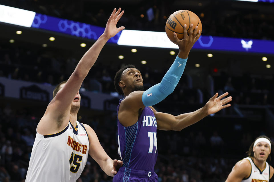 Charlotte Hornets guard Ish Smith (14) shoots against Denver Nuggets center Nikola Jokic during the first half of an NBA basketball game in Charlotte, N.C., Saturday, Dec. 23, 2023. (AP Photo/Nell Redmond)