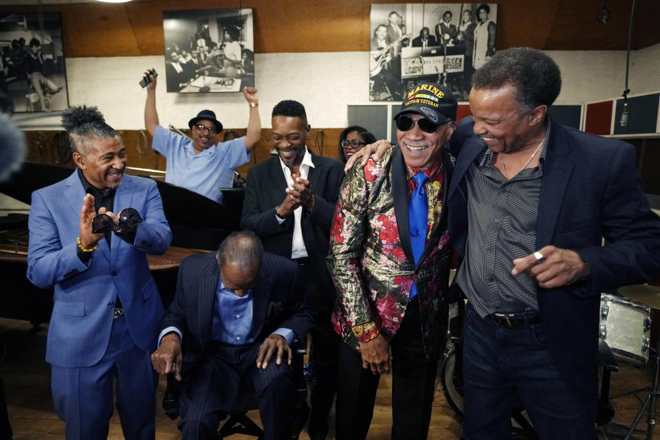 From left,\; Spinners members Ronnie Moss, Henry Fambrough, seated, and Jessie Peck applaud as G.C. Cameron is hugged by Marvin Taylor after Cameron sung one of the group's songs inside Studio A at the Motown Museum, Friday, May 19, 2023, in Detroit. The museum welcomed the iconic soul group where group members donated uniforms and other memorabilia from their Motown days. (AP Photo/Carlos Osorio)