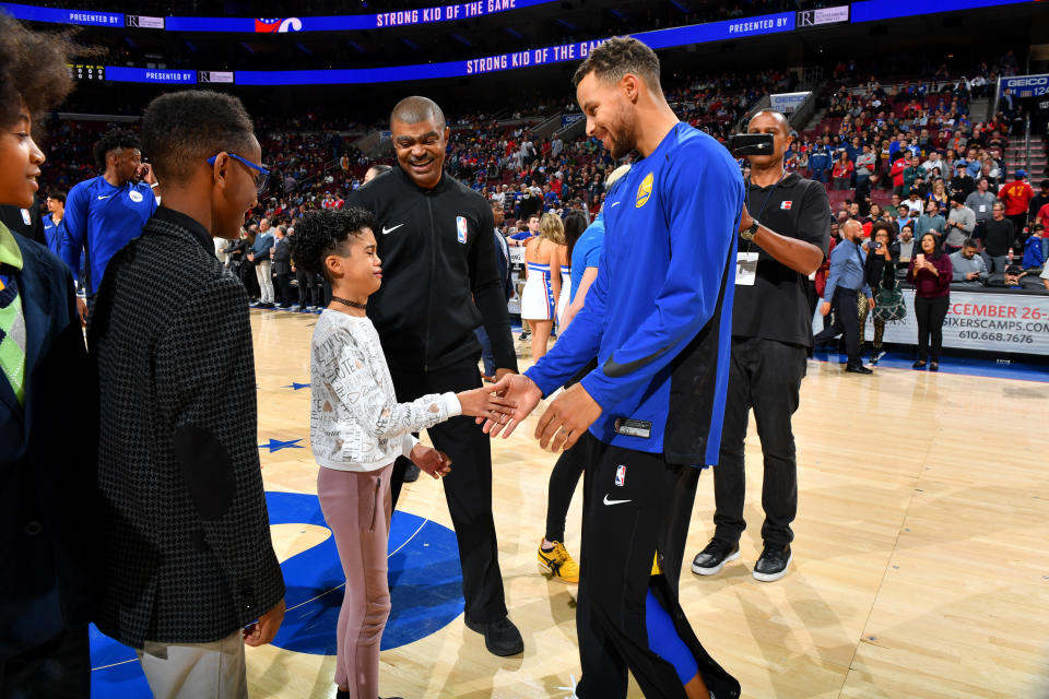 Steph Curry meets a crying fan before the Warriors’ win over the 76ers on Saturday. (Getty)